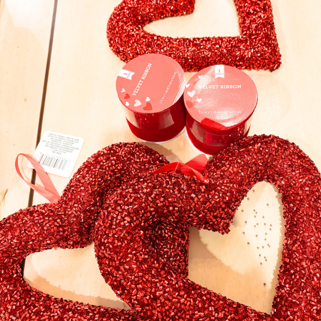3 sparkly red hearts and 2 spools of red velvet ribbon.